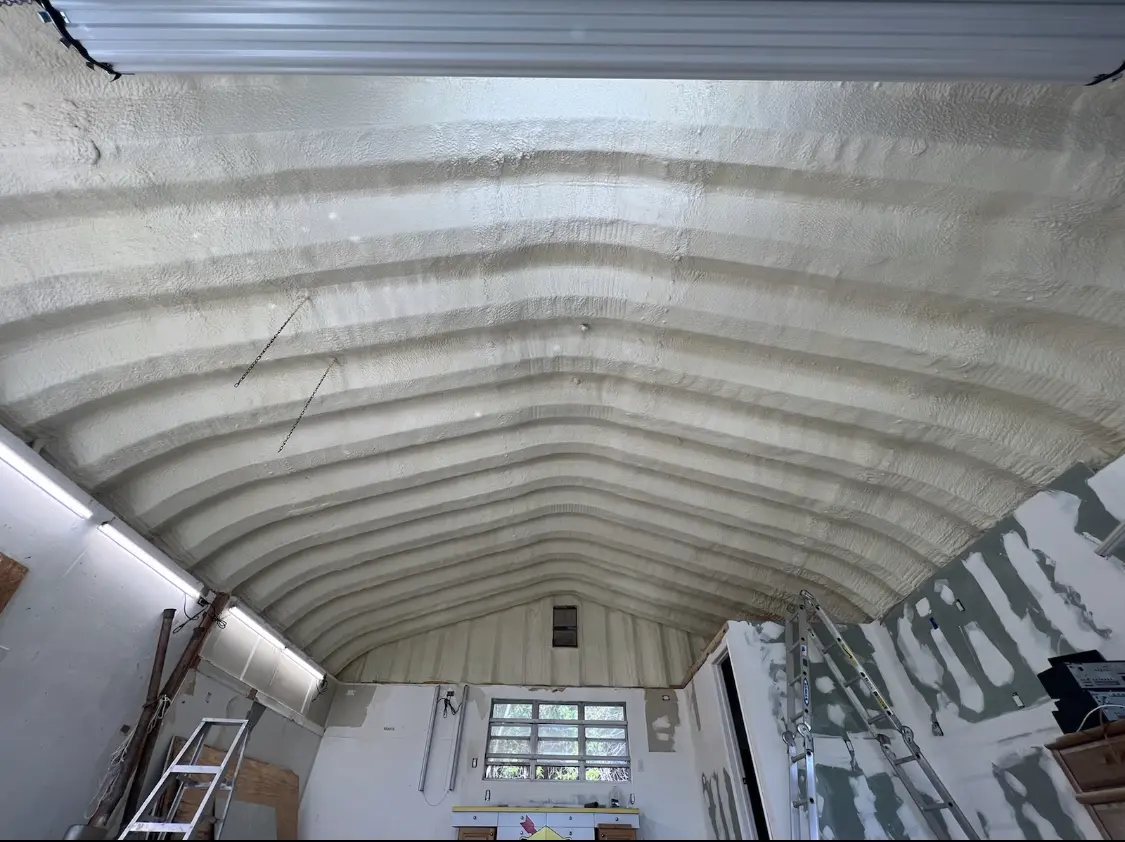 Spray polyurethane foam applied to the underside of a metal roof deck in Kerman